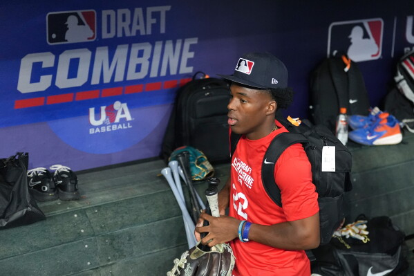 James Clark, a shortstop from St. John Bosco High School, gathers his gear in the dugout at the MLB baseball combine in Phoenix, Tuesday, June 23, 2026. (AP Photo/Ross D. Franklin)