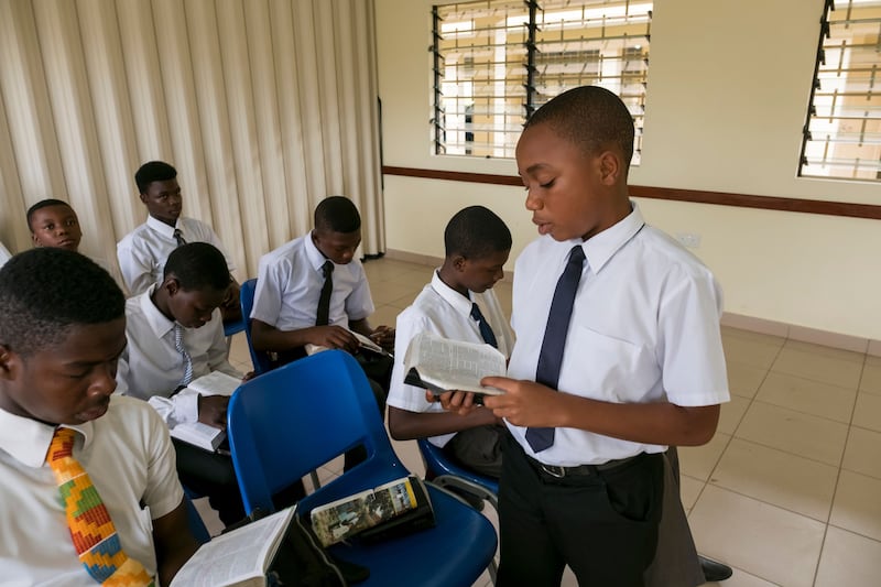 A young Latter-day Saint reads a scripture in his Aaronic Priesthood quorum meeting in Ghana.